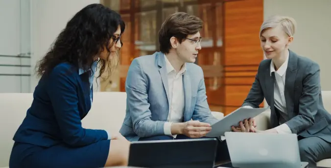 Three professionals reviewing a compliance document