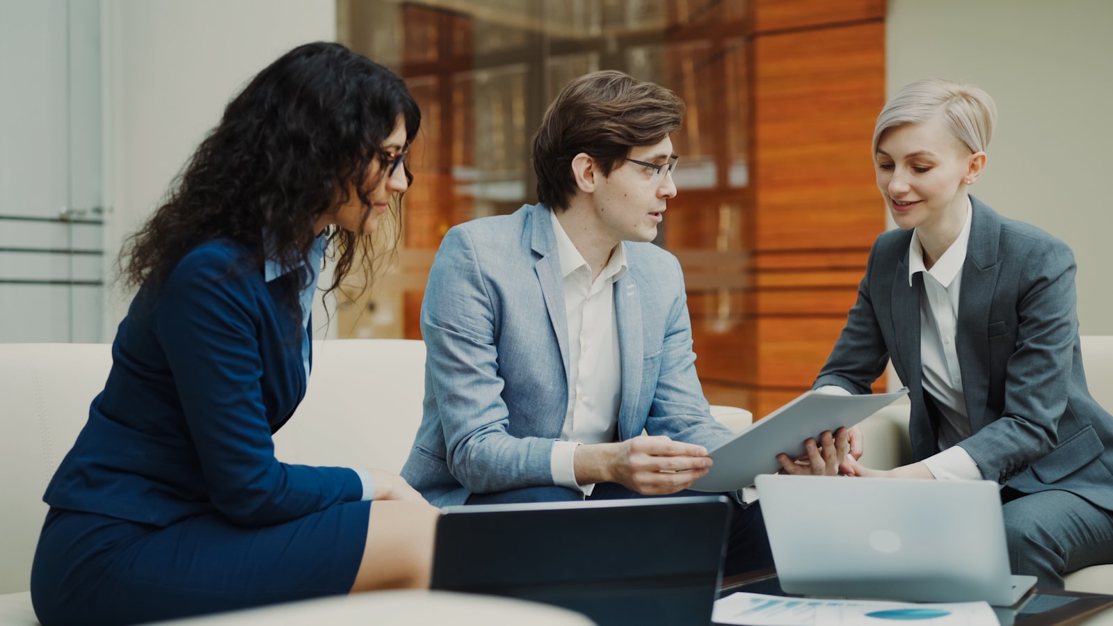 Three professionals reviewing a compliance document