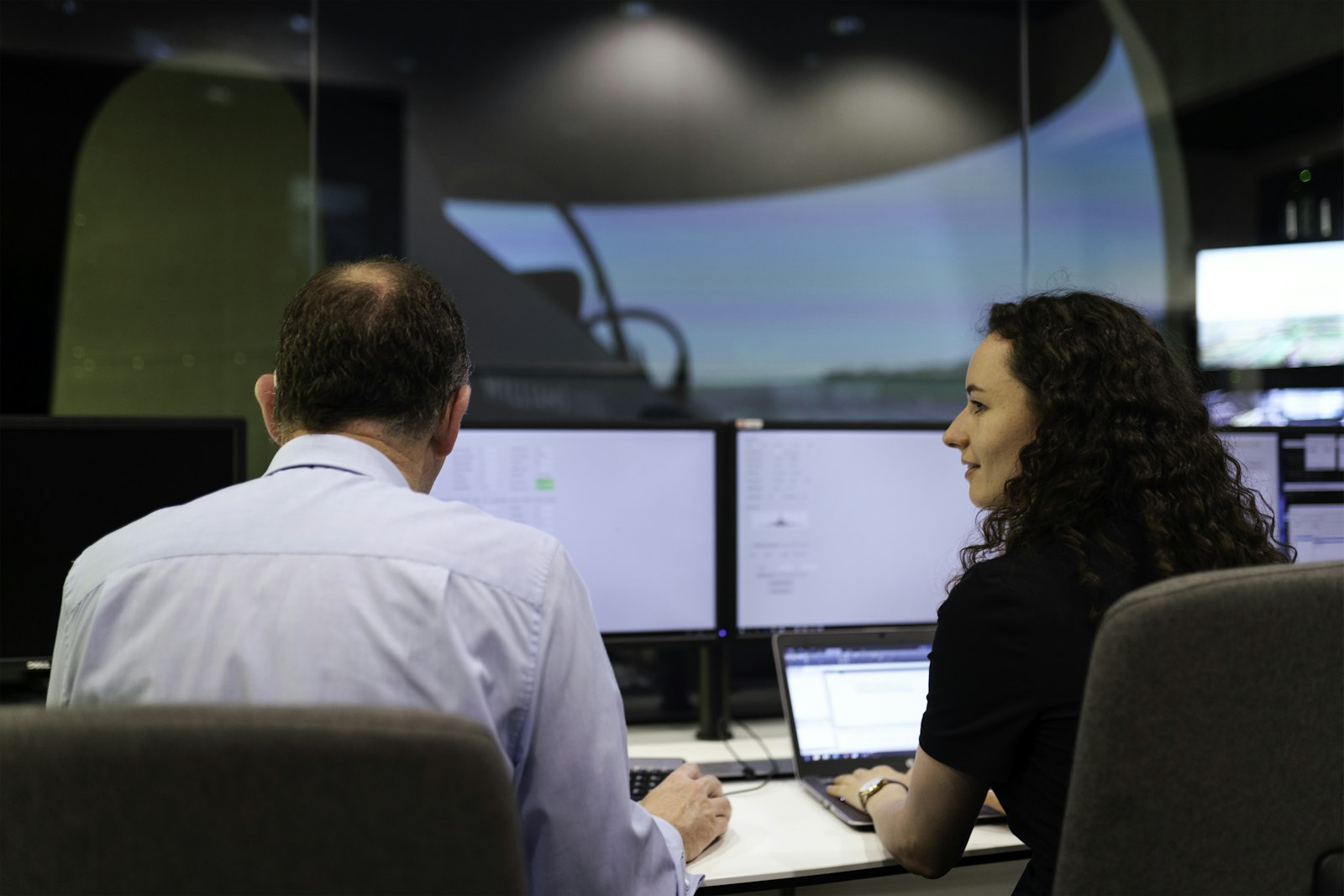 Two engineers monitoring operations on their screens