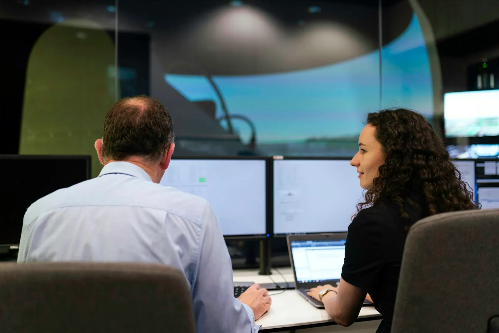 Two engineers monitoring operations on their screens